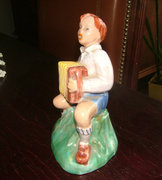Antique ceramic statue: a child with a tango harmonica