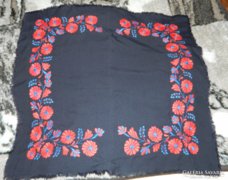 Red-blue floral embroidered tablecloth on a black background