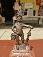 Copper statue of a boy with an umbrella
