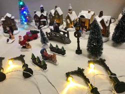 Világító karácsonyi falu Mikulás sál hóemberrel emberekkel kandelláberekkel