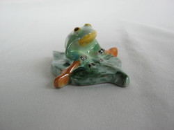 A frog paddling on a ceramic leaf