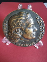 Buck holding a medal, a coin holder or a small plate