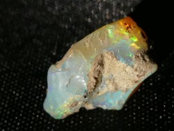 Természetes Etióp Opál ásvány. 0,78 gramm ékszeralapanyag, kék-zöld-sárga-narancssárga csillámokkal.