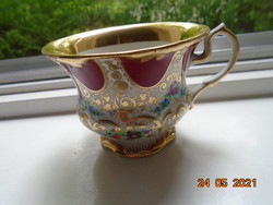 19th century hand-painted tea cup with very fine gold patterns and floral designs, opulently gilded