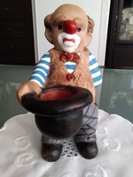 A clown figure with a black hat and a sad face.