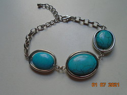 3 large polished bracelets with a turquoise stone that can be rotated on the axis, enclosed in a silver-plated frame