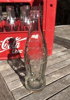 24 pieces of old coca cola in glass compartment.