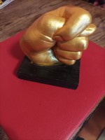 Hand statue showing gold colored fityis