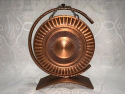 A nice-sounding solid copper lunch gong with a wooden bat, it has material in it