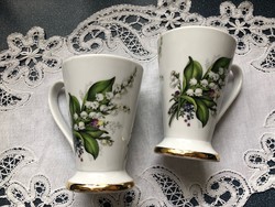 Beautiful coffee pot with white lily of the valley, cup of cappuccino, mug in pairs