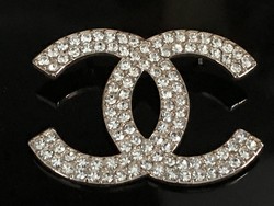 Chanel-shaped brooch with crystals on the metal part with a rose gold coating, 6 x 4.5 cm