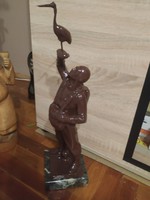 A statue of a man holding a bird on a marble base is for sale!