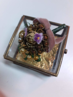Old openable copper-framed glass box with a scented bouquet of flowers inside