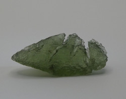 Olive green Moldavit meteorite impact glass grain. Rare, naturally formed piece.