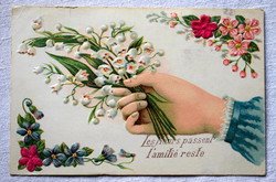 Antique embossed greeting postcard with hand holding lily of the valley