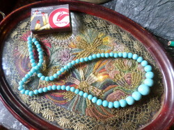 46 Cm light blue necklace with varying eye sizes.