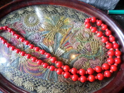 60 Cm necklace of red glass beads of varying mesh size.