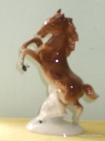 Brown perched porcelain horse.