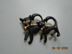 Black cat paired with enameled gilded brooch with polished stone eyes, gilded mustache and bow