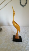 Retro old wooden heron sculpture on wooden pedestal