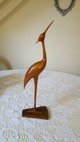 Retro old wooden heron sculpture on wooden pedestal
