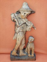 His dog's violin. Wood carving. Wall picture carved from wood.