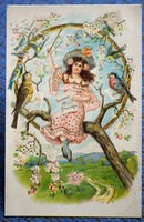 Antique gold-pressed spring greeting litho postcard with girl singing birds on a tree branch