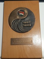 A bronze plaque on a wooden base from the Kisz Csepel Works Committee for the 25th anniversary of the flag-dismantling of Kisz