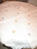 Beautiful hand-embroidered snow-white woven tablecloth with a lace edge