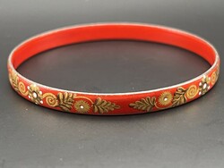 Fire enamel bracelet with a gold flower pattern on a red background