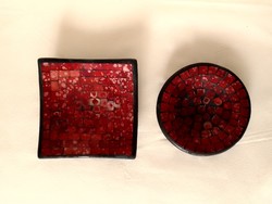 A pair of round and square glass mosaic black and red painted candle holders and candle holders on a plaster base