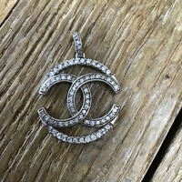 Older coco chanel pattern silver pendant with zircon stones