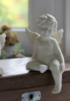 Porcelain sitting putto, angel face