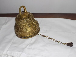 A large patinated copper bell with a chain,