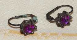 Silver colored antique earrings with a purple stone
