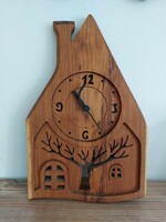 Wall clock in the shape of a house carved from wood