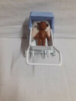 Retro mini metal pram with a small negro baby in it, in preserved condition