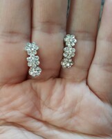 A pair of sparkling earrings with a floral stud closure