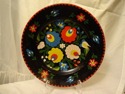 Painted granite wall plate with an embroidered pattern on a black base