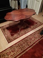 A richly carved baroque table with inlaid spider legs is for sale