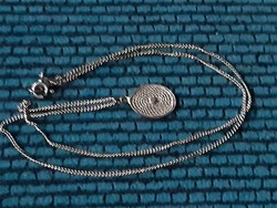 Filigree pierced silver pendant on a thin silver chain