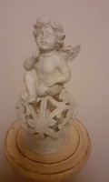 Contemplative angel sitting on a pink sphere, decoration