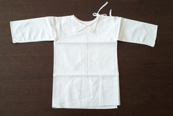 Old shabby baby clothes in traditional costume embroidered on canvas babaing