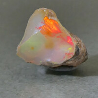 Természetes hidrofán Etióp Opál ásvány. 0,61 gramm ékszeralapanyag, kék-vörös-sárga csillámokkal.