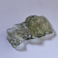 Olive green Moldavit meteorite impact glass grain. Rare, naturally formed piece.