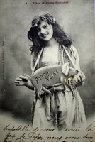 Antique photo postcard of a cheerful lady with a pig