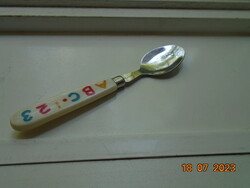 Stainless steel children's spoon marked with a colored alphabetic handle