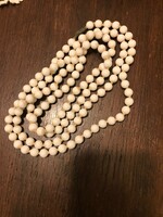 124 cm long, white bisque pearl string necklace with knotted lacing.