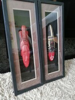 2 wooden carved totem heads in a frame