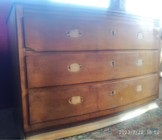 Three-drawer, curved chest of drawers with elegant copper trim